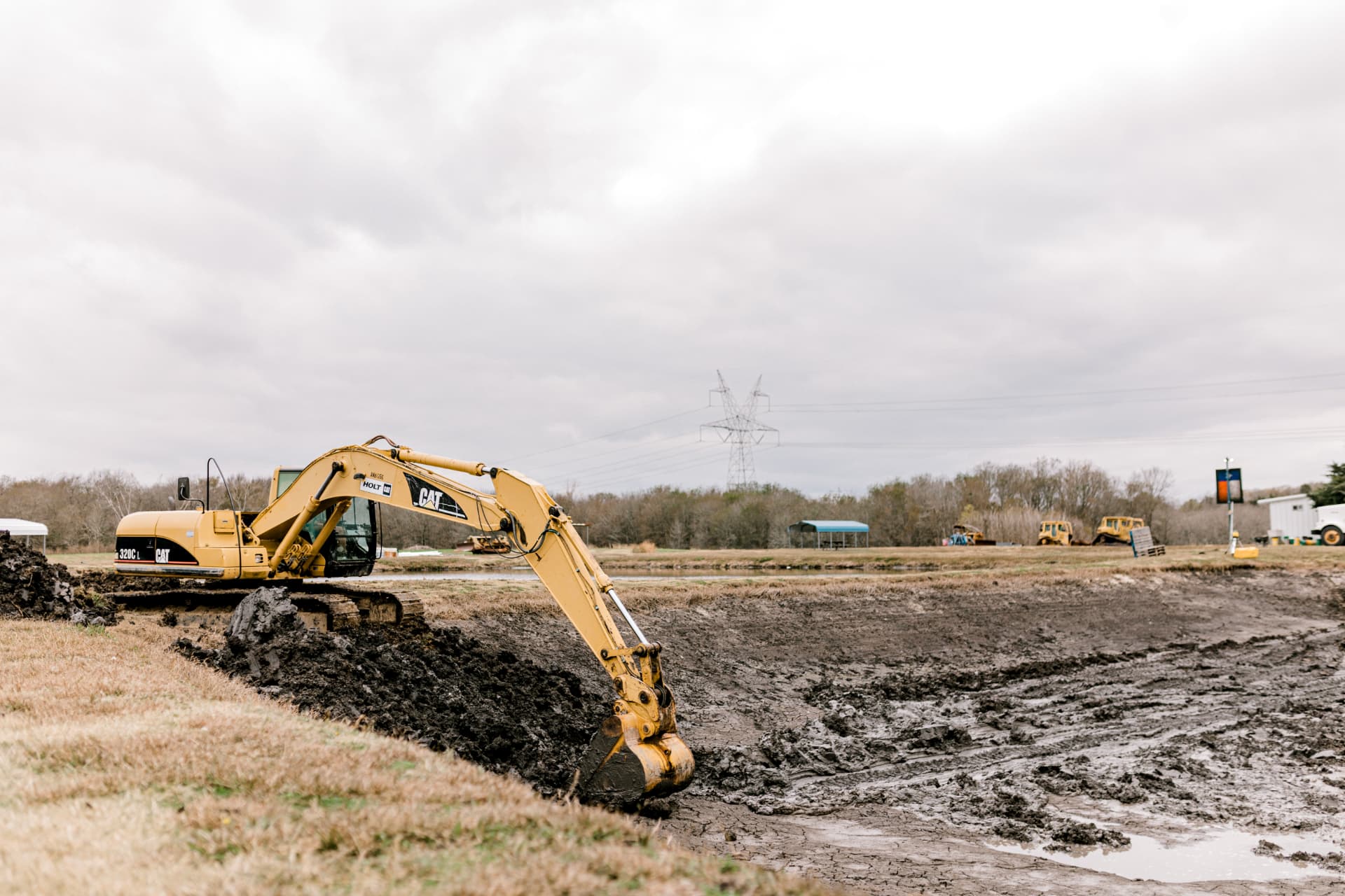 Texas Fishing LLC excavator digging a new pond basin on a cloudy day