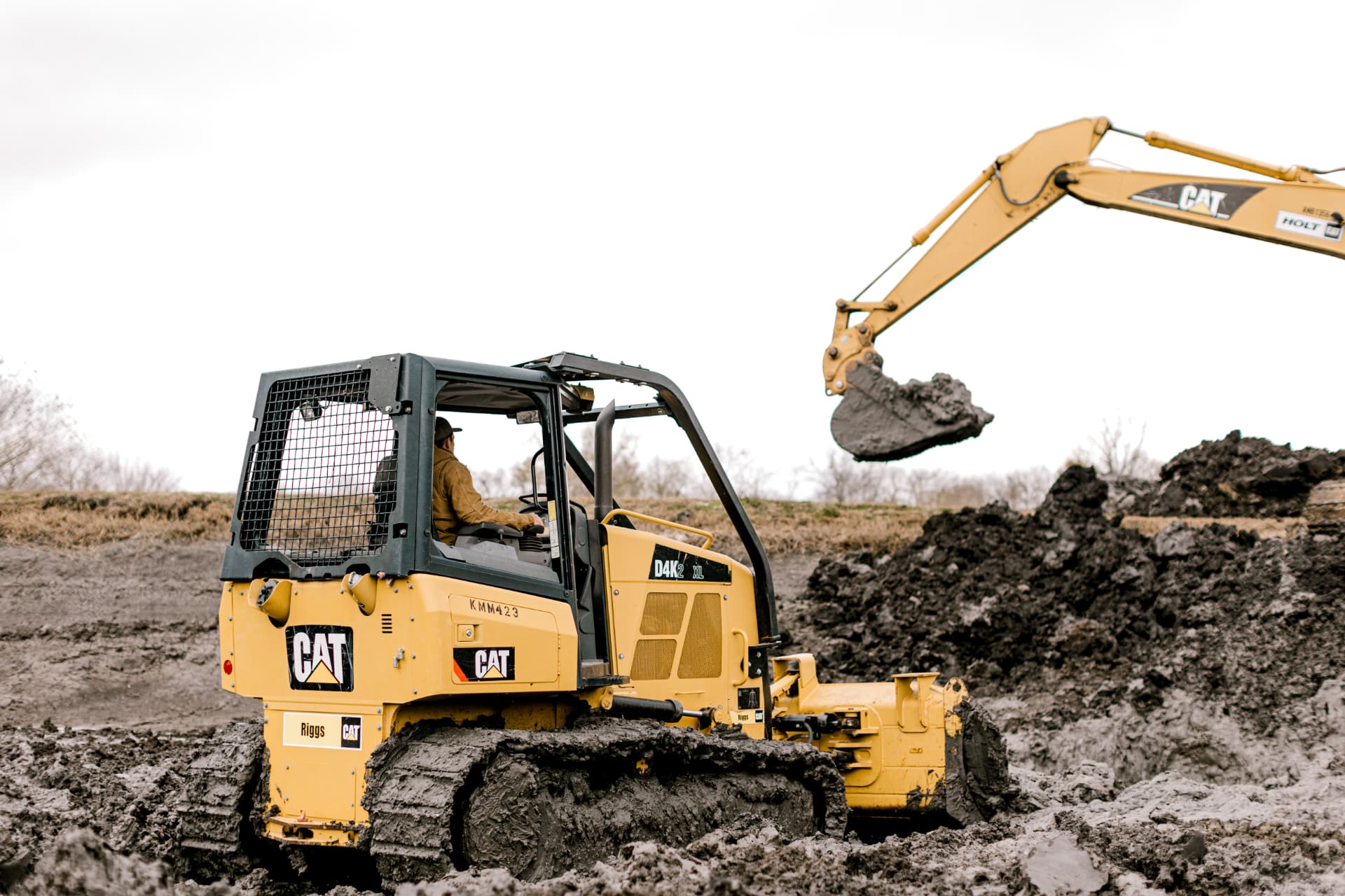 Dozer and excavator shaping the dam of a new private pond on Texas land